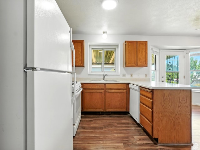 3992 S 4665 W, West Valley City, UT 84120 - kitchen featuring white appliances, a peninsula, dark wood finished floors, light countertops, and brown cabinetry