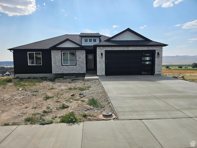 1569 N 300 E, Nephi, UT 84648 - view of front of home with concrete driveway, a garage, a mountain view, and stone siding