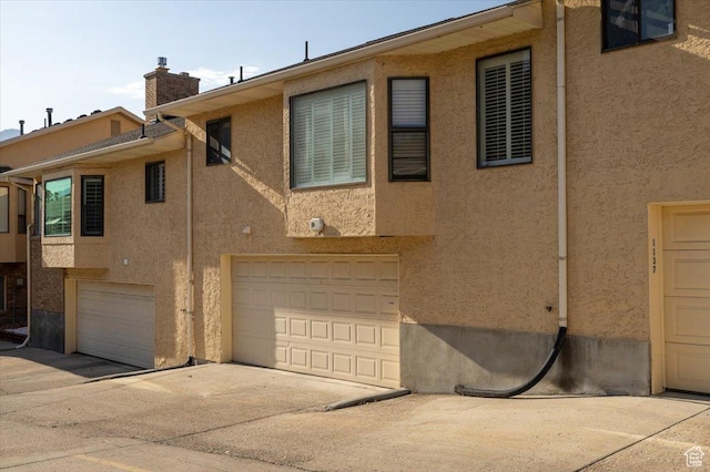 1141 E Murray Holladay Rd S, Millcreek, UT 84117 - view of property exterior with stucco siding, a chimney, and driveway