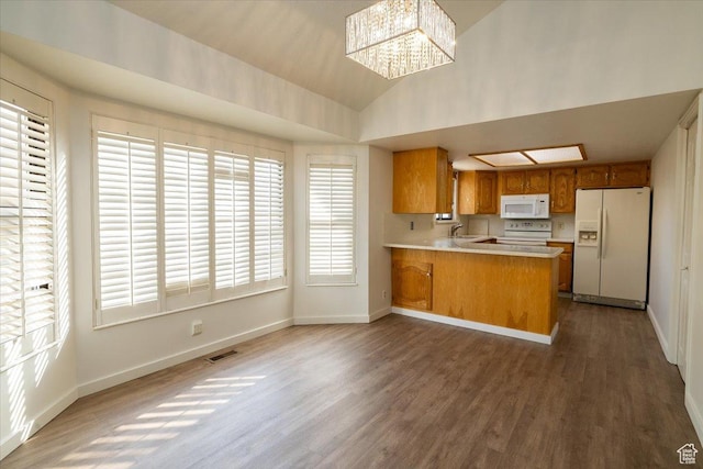 1141 E Murray Holladay Rd S, Millcreek, UT 84117 - kitchen featuring white appliances, wood finished floors, a peninsula, light countertops, and brown cabinetry