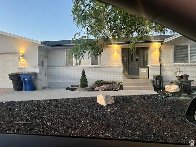 6319 W 13400 S, Herriman, UT 84096 - view of exterior entry with brick siding, an attached garage, and driveway