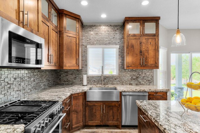 13703 S Blayde Dr, Herriman, UT 84096 - kitchen featuring stainless steel appliances, backsplash, light stone countertops, recessed lighting, and decorative light fixtures
