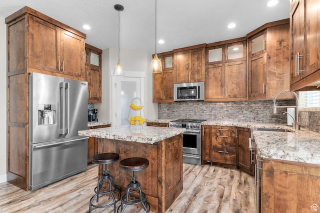 13703 S Blayde Dr, Herriman, UT 84096 - kitchen with premium appliances, light wood-style flooring, a center island, decorative backsplash, and recessed lighting
