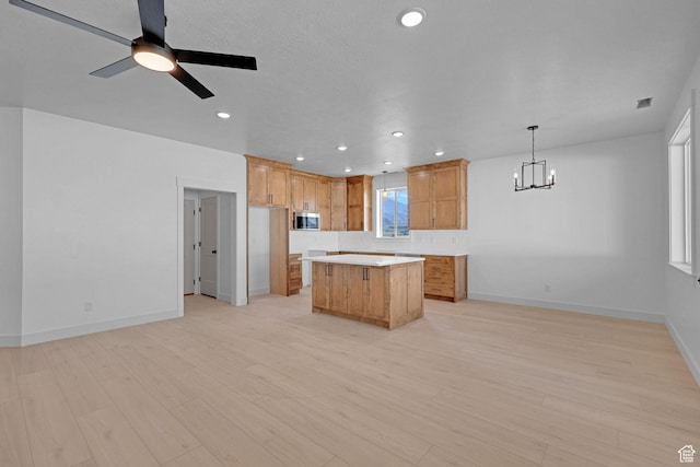 496 S 30 E, Franklin, ID 83237 - kitchen with stainless steel microwave, a center island, a chandelier, light countertops, and light wood-style flooring