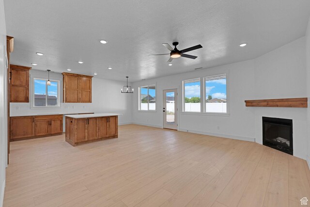 496 S 30 E, Franklin, ID 83237 - kitchen with brown cabinets, open floor plan, a center island, a fireplace, and recessed lighting