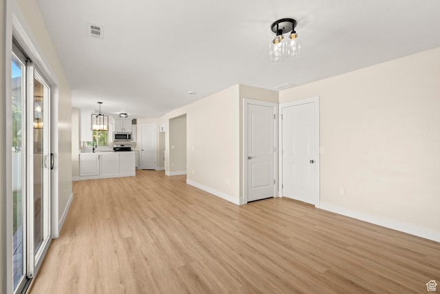 4012 N Bounty Cv W, Lehi, UT 84043 - unfurnished living room with a chandelier and light wood finished floors