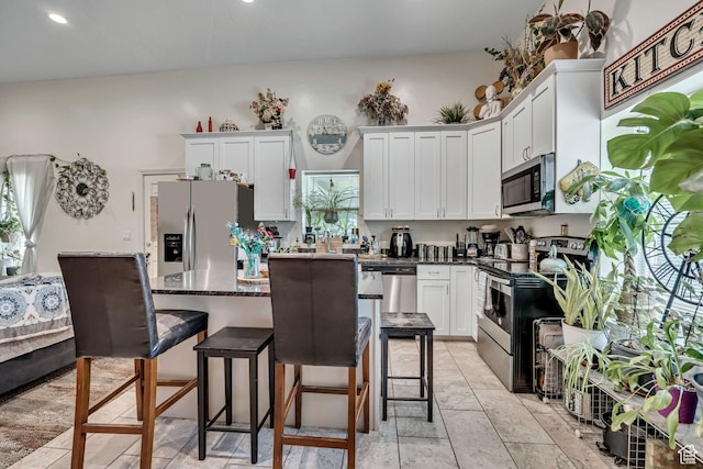 3981 S 500 E, Millcreek, UT 84107 - kitchen with stainless steel appliances, white cabinetry, a breakfast bar, a kitchen island, and recessed lighting