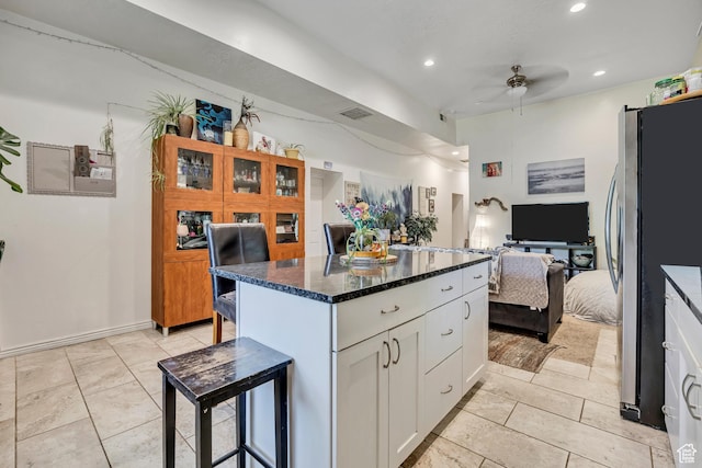 3981 S 500 E, Millcreek, UT 84107 - kitchen featuring freestanding refrigerator, a ceiling fan, a kitchen bar, white cabinetry, and open floor plan