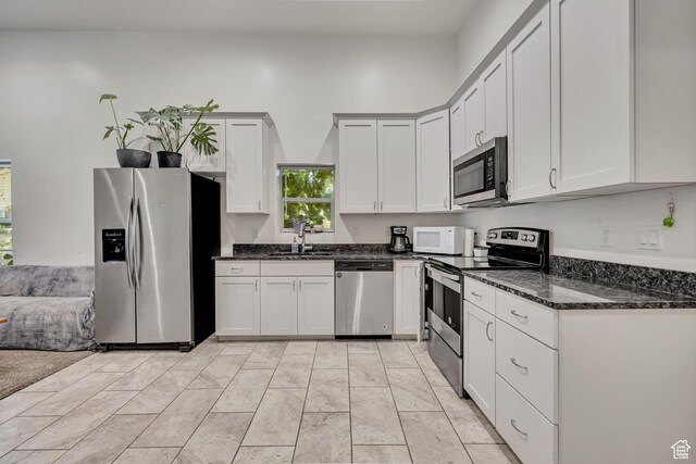 3981 S 500 E, Millcreek, UT 84107 - kitchen with appliances with stainless steel finishes, dark stone counters, and white cabinetry