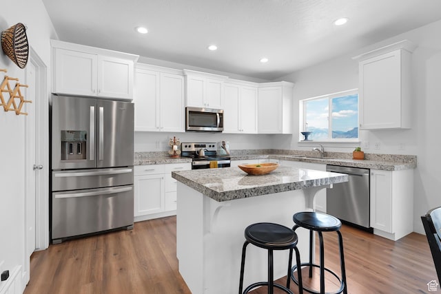 4925 E Breezy Patch Rd, Eagle Mountain, UT 84005 - kitchen featuring appliances with stainless steel finishes, dark wood-style floors, recessed lighting, white cabinetry, and a kitchen island