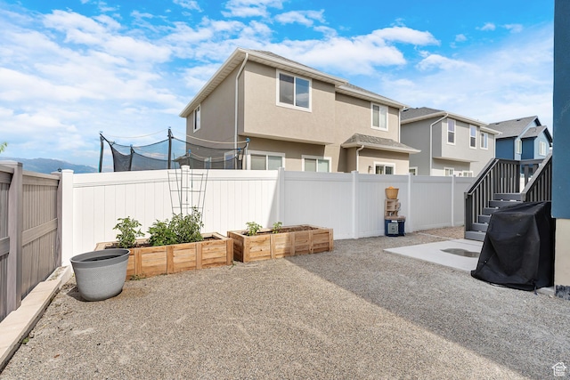 4925 E Breezy Patch Rd, Eagle Mountain, UT 84005 - fenced backyard with a vegetable garden and a residential view