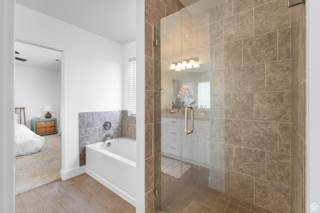 4925 E Breezy Patch Rd, Eagle Mountain, UT 84005 - bathroom featuring a garden tub, wood finished floors, a shower stall, and healthy amount of natural light
