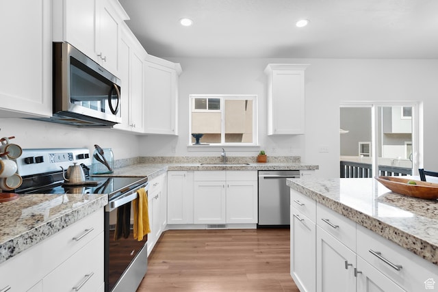 4925 E Breezy Patch Rd, Eagle Mountain, UT 84005 - kitchen with stainless steel appliances, white cabinetry, light wood finished floors, recessed lighting, and light stone countertops