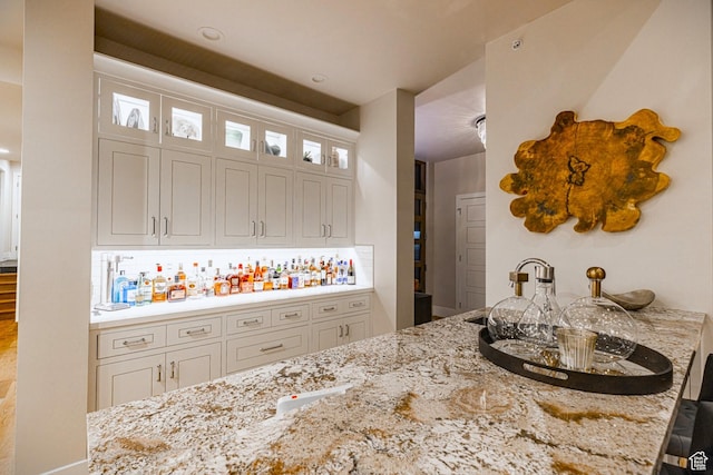 6423 Golden Bear Loop Unit 5, Park City, UT 84098 - kitchen featuring light stone countertops, glass insert cabinets, white cabinets, backsplash, and a breakfast bar area