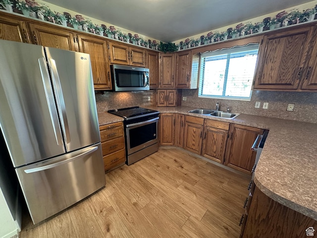 487 Highland Blvd, Brigham City, UT 84302 - kitchen with appliances with stainless steel finishes, light wood-style floors, backsplash, dark countertops, and brown cabinets