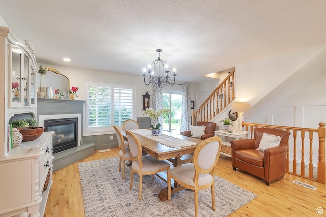 314 E 1290 S, Payson, UT 84651 - dining area with a chandelier, light wood-style floors, a glass covered fireplace, a textured ceiling, and stairway