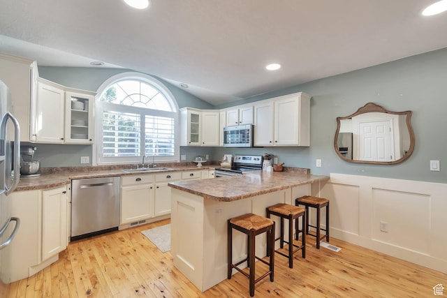 314 E 1290 S, Payson, UT 84651 - kitchen featuring appliances with stainless steel finishes, a peninsula, light wood-style flooring, glass insert cabinets, and vaulted ceiling