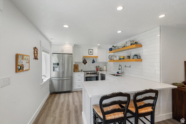 605 W 1660 S, Provo, UT 84601 - kitchen with appliances with stainless steel finishes, a peninsula, light wood-style flooring, light countertops, and tasteful backsplash