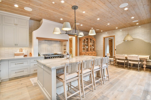 5155 E Canyon Rd, Morgan, UT 84050 - kitchen with wood ceiling, an island with sink, white cabinets, gas range, and light wood-style floors