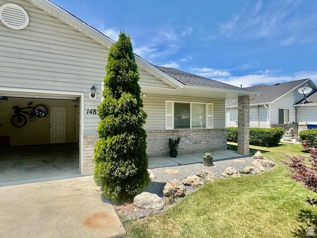 1485 N Monroe Blvd E, Ogden, UT 84404 - view of side of property with brick siding, concrete driveway, a lawn, and a garage