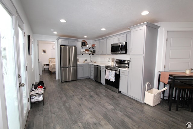 6255 N Wanlass Hl, Eagle Mountain, UT 84005 - kitchen featuring stainless steel appliances, open shelves, gray cabinetry, dark wood-style flooring, and recessed lighting
