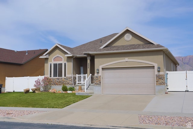 6628 N Malachite Way, Stansbury Park, UT 84074 - single story home featuring stone siding, stucco siding, driveway, an attached garage, and a gate