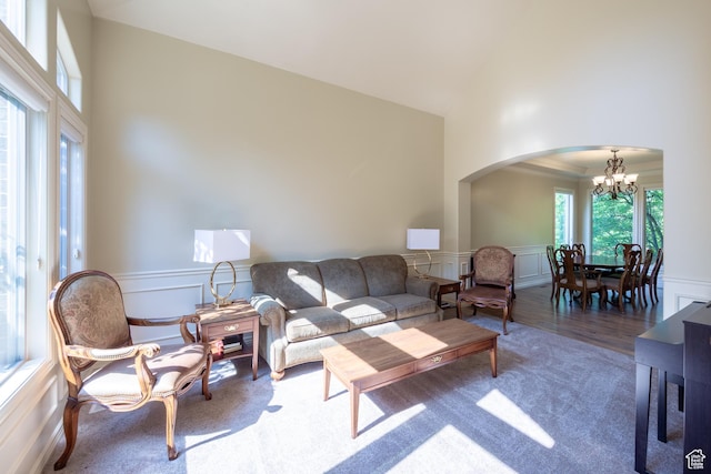 357 N Main St, Alpine, UT 84004 - carpeted living area featuring high vaulted ceiling, arched walkways, a chandelier, a decorative wall, and a wainscoted wall