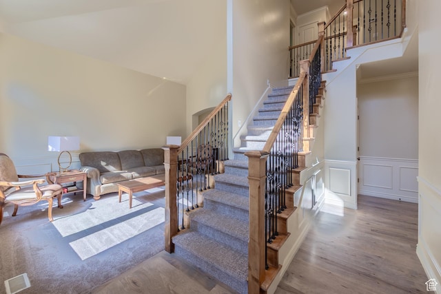 357 N Main St, Alpine, UT 84004 - staircase with wood finished floors, a towering ceiling, a decorative wall, ornamental molding, and wainscoting