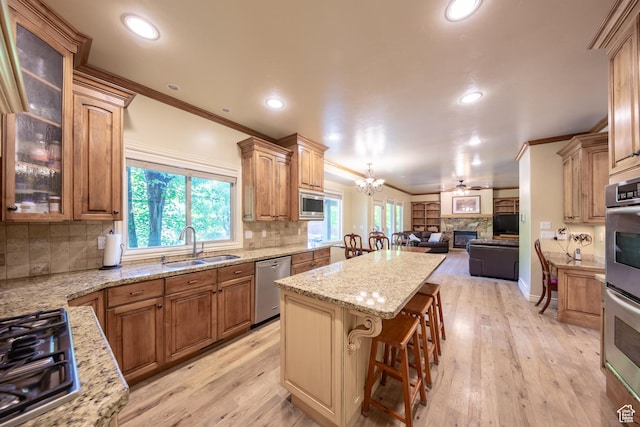 357 N Main St, Alpine, UT 84004 - kitchen featuring appliances with stainless steel finishes, a center island, open floor plan, ornamental molding, and a fireplace