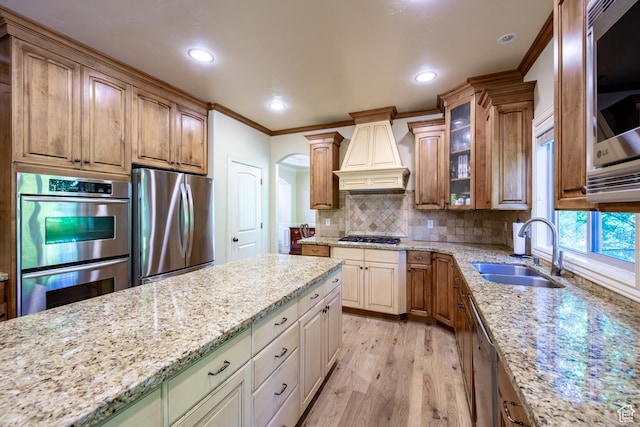357 N Main St, Alpine, UT 84004 - kitchen with appliances with stainless steel finishes, custom exhaust hood, ornamental molding, light stone counters, and light wood-style flooring