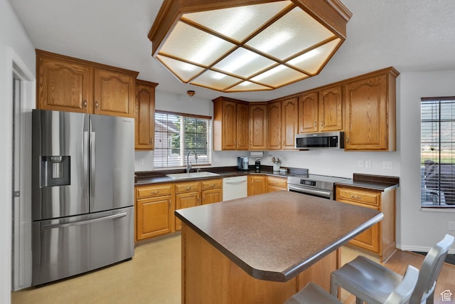 563 S 1850 E, Spanish Fork, UT 84660 - kitchen featuring stainless steel appliances, dark countertops, brown cabinetry, and a kitchen bar