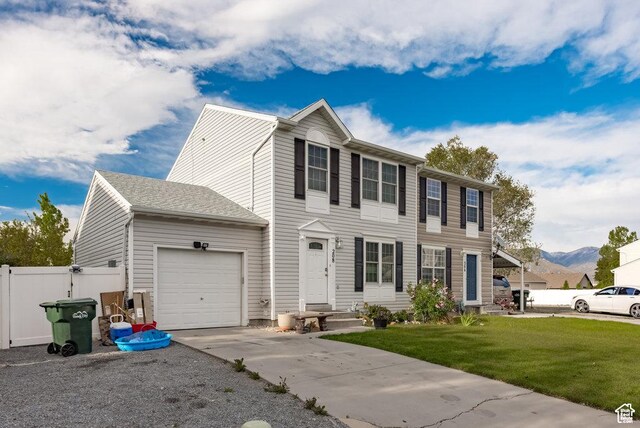 208 Alfred Dr, Tooele, UT 84074 - view of front of home with an attached garage, driveway, and a mountain view