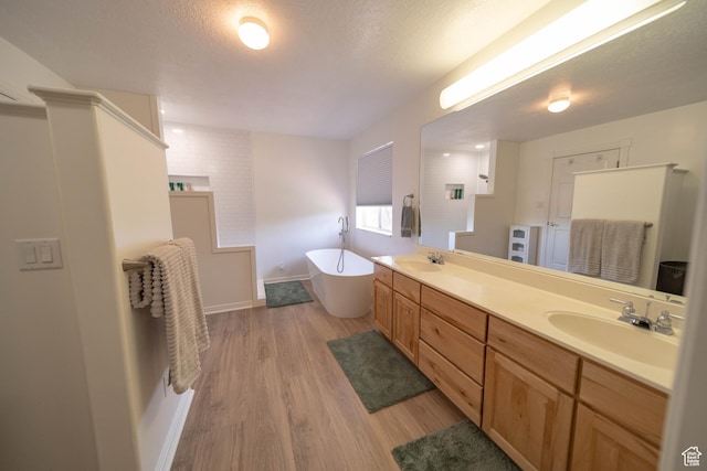 190 E 600 N, Ferron, UT 84523 - bathroom with a freestanding tub, double vanity, wood finished floors, and a textured ceiling