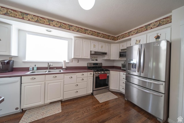 190 E 600 N, Ferron, UT 84523 - kitchen featuring stainless steel appliances, under cabinet range hood, dark wood-type flooring, white cabinetry, and dark countertops