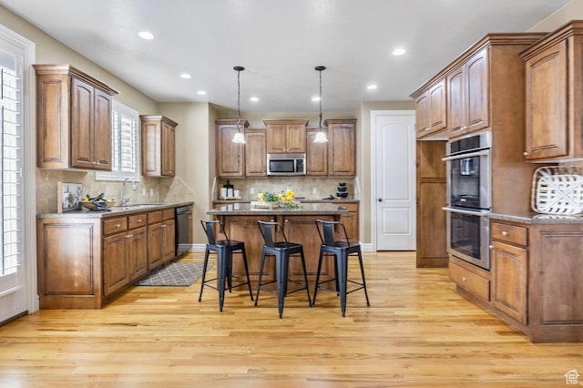 1362 E Shays Grove, Murray, UT 84121 - kitchen with appliances with stainless steel finishes, a center island, light wood-type flooring, healthy amount of natural light, and recessed lighting