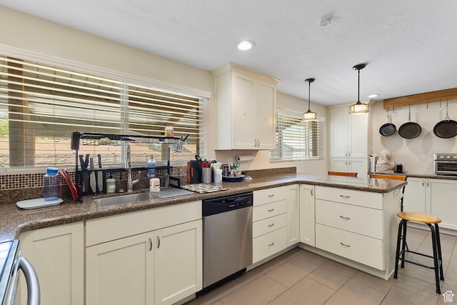 6110 S 725 E, Murray, UT 84107 - kitchen with stainless steel dishwasher, pendant lighting, a peninsula, range, and a textured ceiling