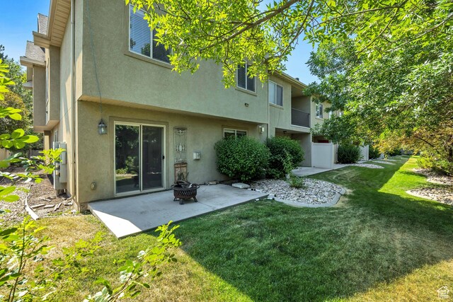 2725 S 700 E Unit O, Salt Lake City, UT 84106 - rear view of property with stucco siding, a patio, a lawn, and a fire pit