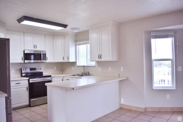 480 N 550 W, Huntington, UT 84528 - kitchen featuring stainless steel appliances, light tile patterned floors, white cabinets, a peninsula, and light countertops