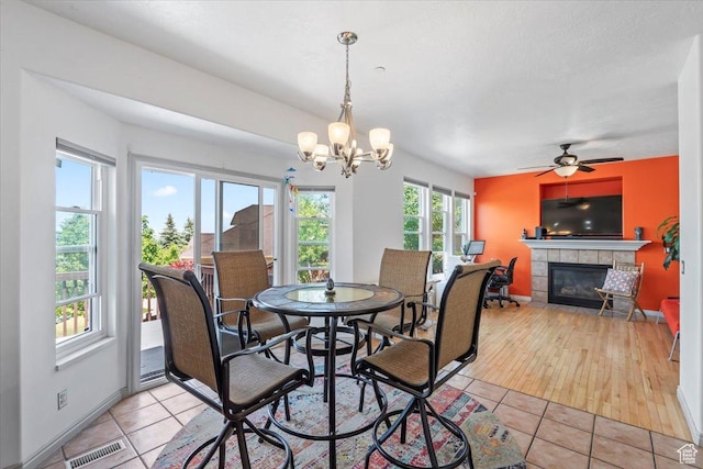 1721 E Lone Oak Dr, Draper, UT 84020 - dining area with a fireplace, light tile patterned floors, a chandelier, and a ceiling fan