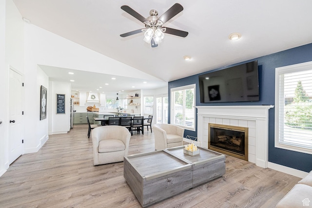 2524 W Martingale Cir S, South Jordan, UT 84095 - living area featuring light wood-style flooring, a tiled fireplace, lofted ceiling, a ceiling fan, and recessed lighting