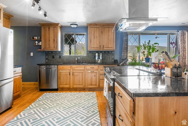 1455 S Hoytsville Rd, Coalville, UT 84017 - kitchen with appliances with stainless steel finishes, ventilation hood, light wood-type flooring, a textured ceiling, and backsplash