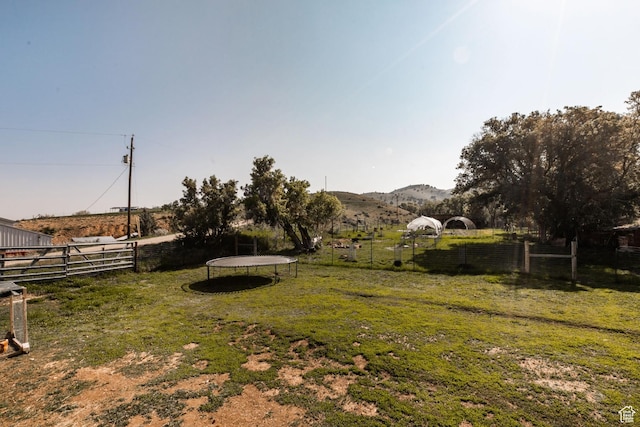 1455 S Hoytsville Rd, Coalville, UT 84017 - view of yard featuring a trampoline, a mountain view, and a view of rural / pastoral area