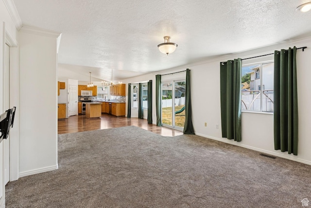 2198 N 1600 E, Layton, UT 84040 - unfurnished living room with a chandelier, dark carpet, healthy amount of natural light, a textured ceiling, and crown molding