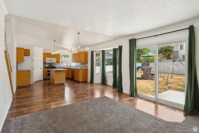2198 N 1600 E, Layton, UT 84040 - kitchen with appliances with stainless steel finishes, a chandelier, brown cabinetry, a textured ceiling, and a center island