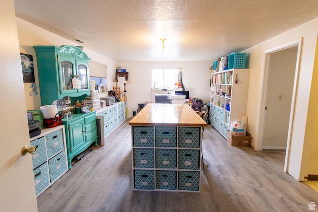1471 W Stern Dr S, Taylorsville, UT 84123 - kitchen featuring butcher block counters, light wood-style flooring, a textured ceiling, and a center island