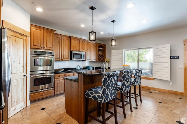 5596 N Oslo Ln, Park City, UT 84098 - kitchen with appliances with stainless steel finishes, dark countertops, brown cabinetry, a kitchen breakfast bar, and pendant lighting