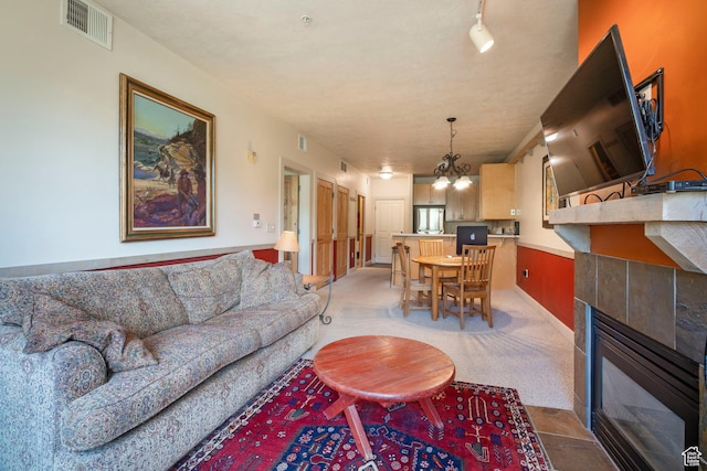 6605 N 2200 W Unit E205, Park City, UT 84098 - living room with a fireplace, a chandelier, and light carpet