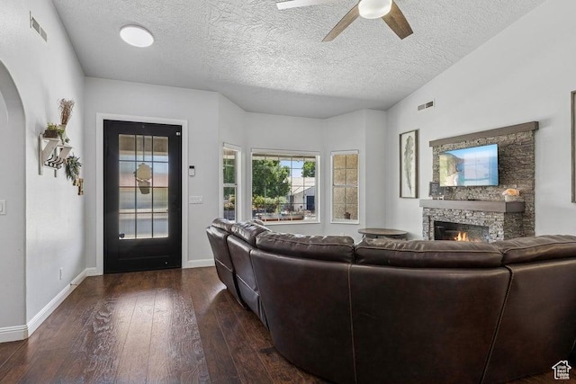 1755 E 2370 S, St George, UT 84790 - living area featuring a stone fireplace, a ceiling fan, dark wood finished floors, arched walkways, and a textured ceiling