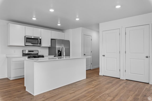 554 W 1870 S Unit 1194, Provo, UT 84601 - kitchen with appliances with stainless steel finishes, a center island with sink, light wood-style floors, light countertops, and white cabinetry