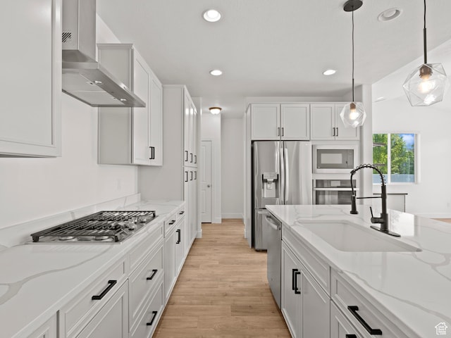 928 S 120 W, American Fork, UT 84003 - kitchen featuring wall chimney exhaust hood, appliances with stainless steel finishes, white cabinets, decorative light fixtures, and recessed lighting